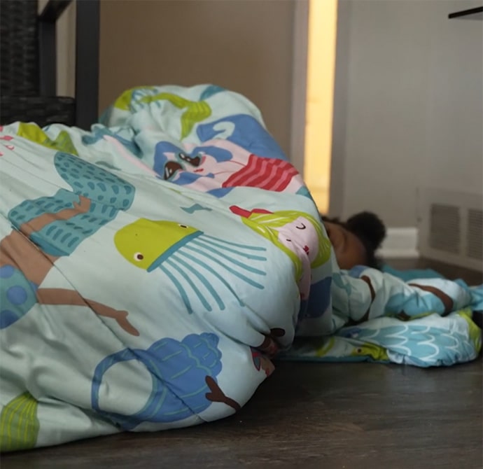 Girl sleeping on floor in sleeping bag