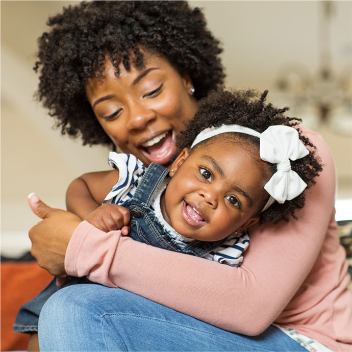 Mother holding daughter on new couch